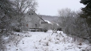Huis vanuit de tuin met sneeuw